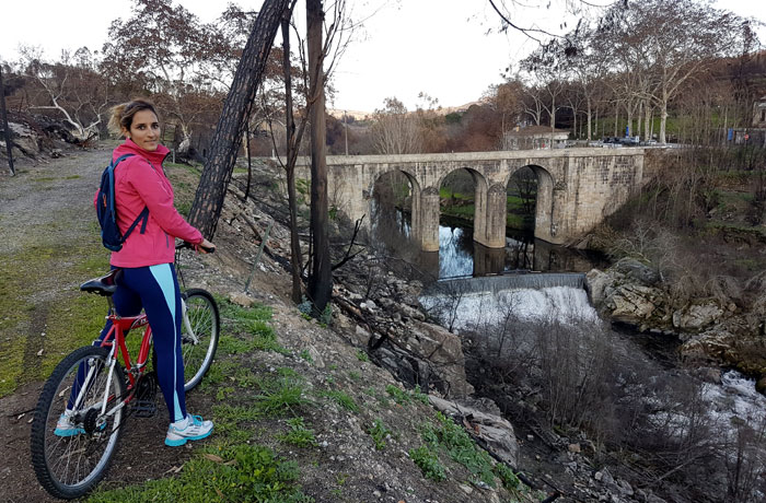 Con la bicicleta, junto al puente sobre el río Mondego